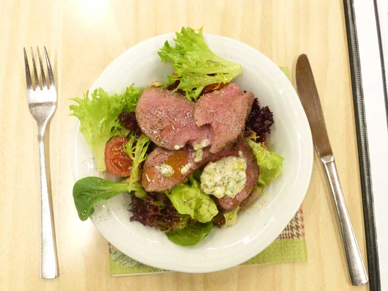 Teller mit Fleisch auf Salatbett